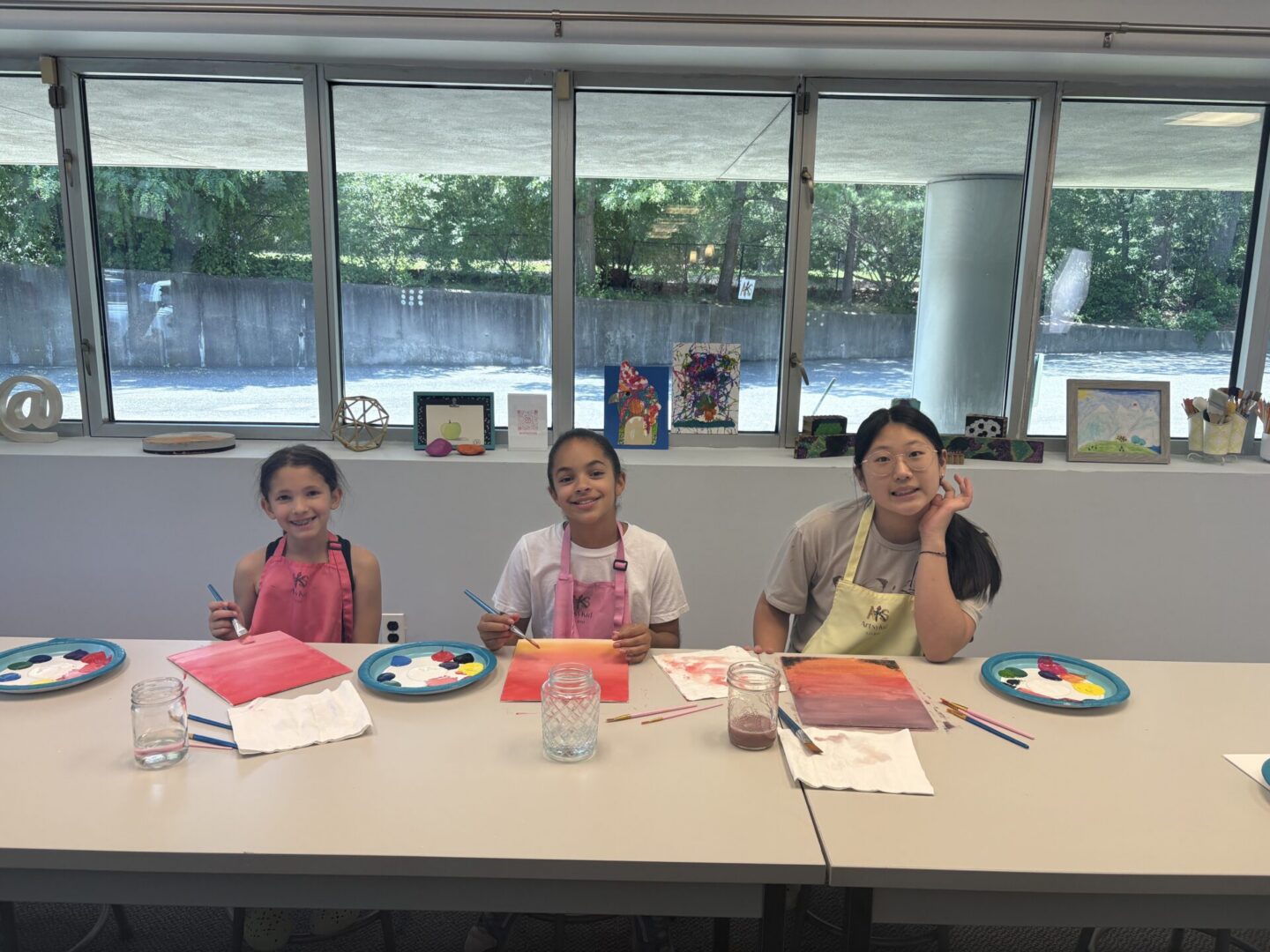 Three girls painting at a table
