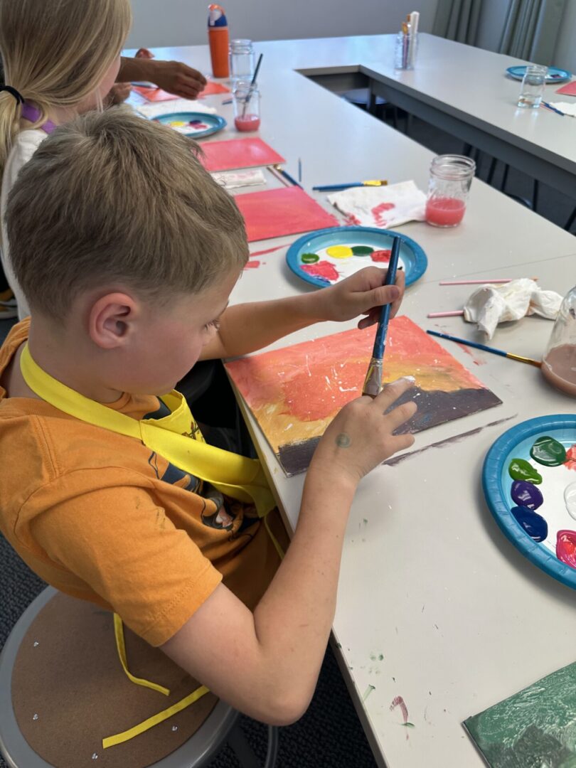 Child painting at a craft table