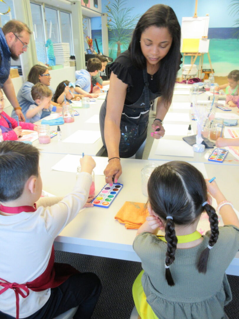 Art teacher helping children with watercolor paints