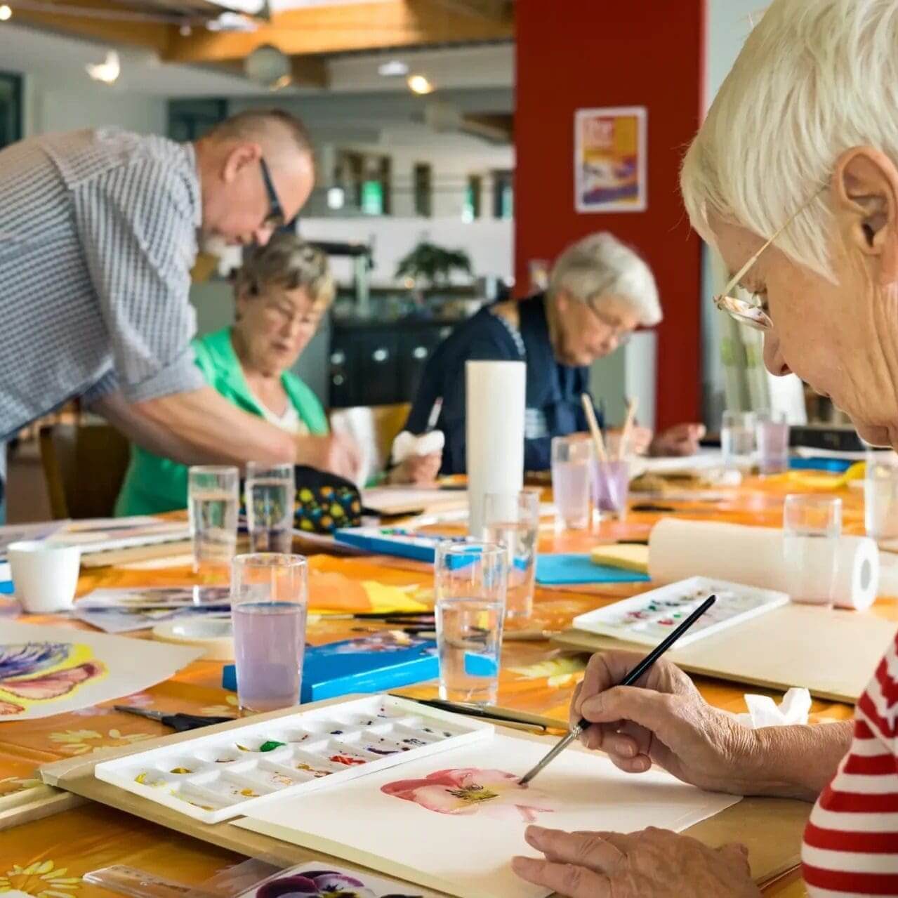 Seniors painting together at community art table