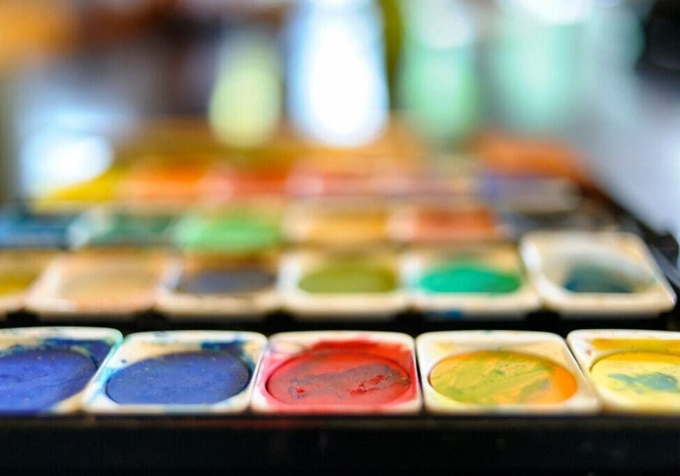 Colorful watercolor paint palette in focus.